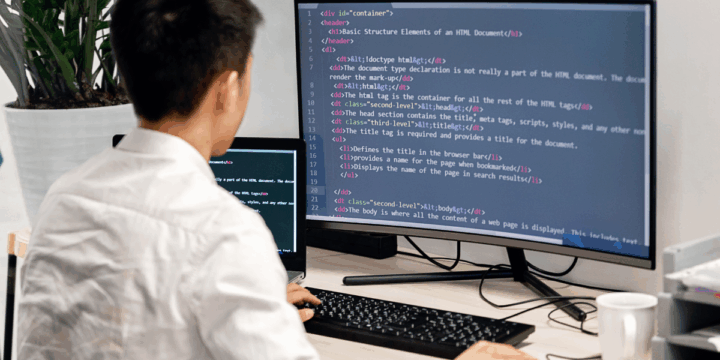 Student werkt aan een computer en programmeert in HTML, zichtbaar op het beeldscherm, als onderdeel van de DIGIT mbo module voor webontwikkeling en digitale vaardigheden.